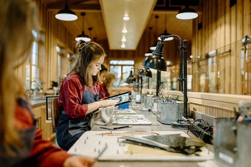 Young student working in stained glass and candle shop